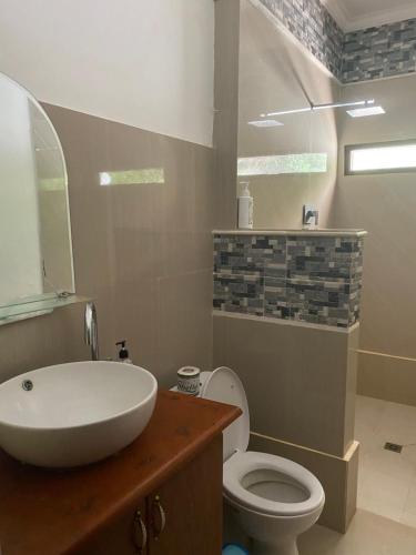 La salle de bains est pourvue d'un lavabo blanc et de toilettes. dans l'établissement Villa Buahan, à Bangli