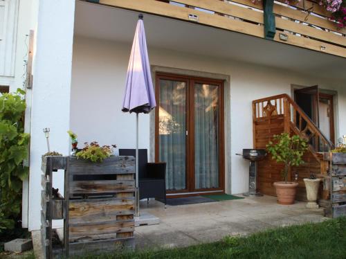 a patio with an umbrella and a house at Ferienwohnung Mittendrin - Chiemgau Karte in Inzell