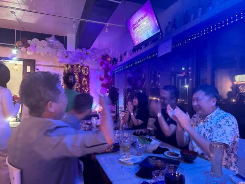 un grupo de personas sentadas en un bar en Shared residence　BAR　DE‘CEBU, en Akamine