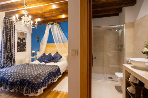 a bedroom with a bed and a bathroom with a shower at Posada de Eufrasio in Lerma