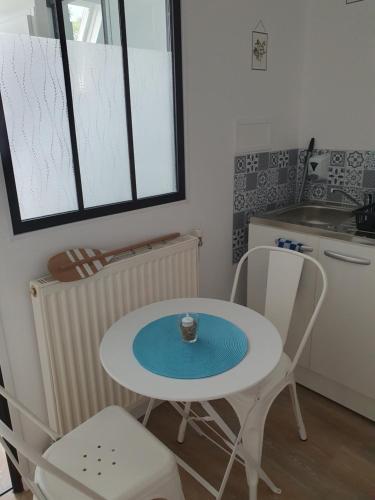 a small kitchen with a table and two chairs at Au fil des saisons in Grézillé