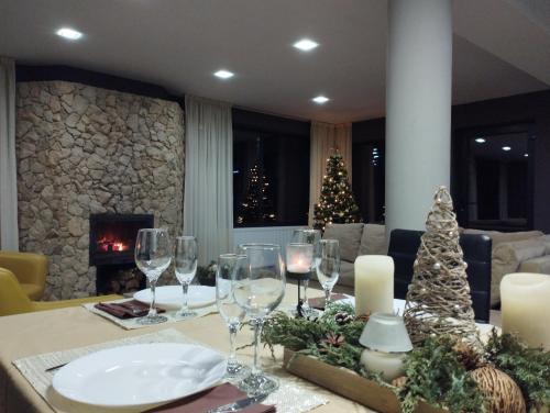 a dining room table with wine glasses and a christmas tree at Vila Gosen in Şard