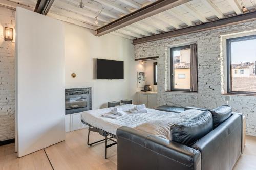 uma sala de estar com um sofá e uma lareira em Loft Santa Chiara - Affitti Brevi Italia em Lucca