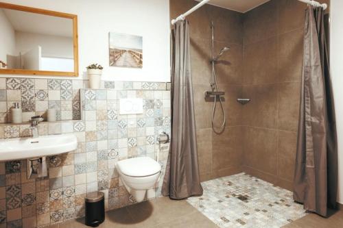 a bathroom with a shower and a toilet and a sink at Wohnung 2 in Hagermarsch