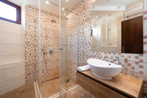 a bathroom with a sink and a glass shower at Heritage Hotel Tragos in Trogir