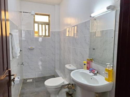 ein weißes Bad mit einem WC und einem Waschbecken in der Unterkunft Pridelands Homes in Nairobi