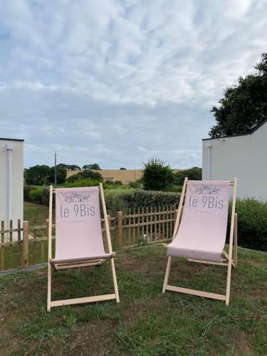 two chairs sitting in the grass in front of a fence at Gîte le 9 bis Kervadail in Baden