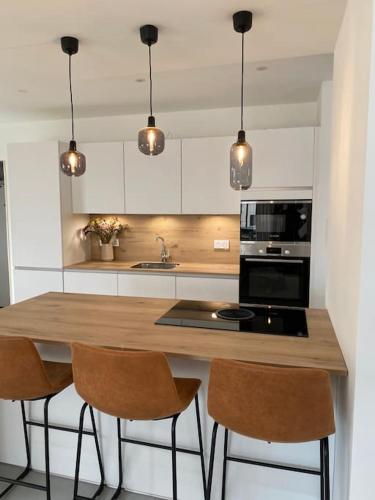 a kitchen with a wooden counter top with three chairs at Gîte le 9 bis Kervadail in Baden