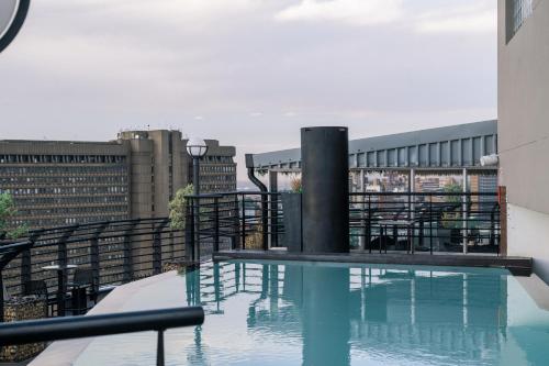 约翰内斯堡The Parktonian All Suite Hotel的建筑物屋顶上的游泳池