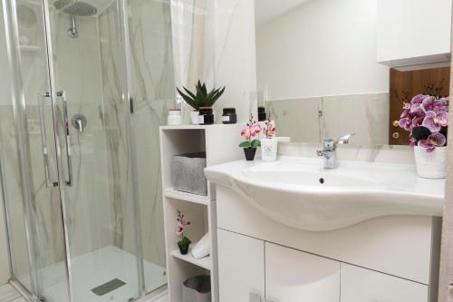 a white bathroom with a sink and a shower at Salmini Porta Romana Apartment in Milan