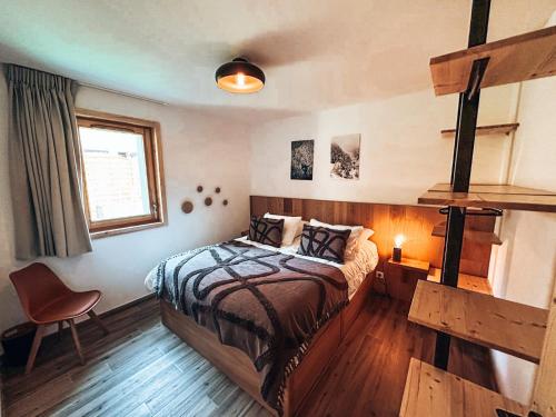 une chambre avec un lit et une chaise dedans dans l'établissement Génépi, Appartement de charme 6 pers., au Monêtier-les-Bains
