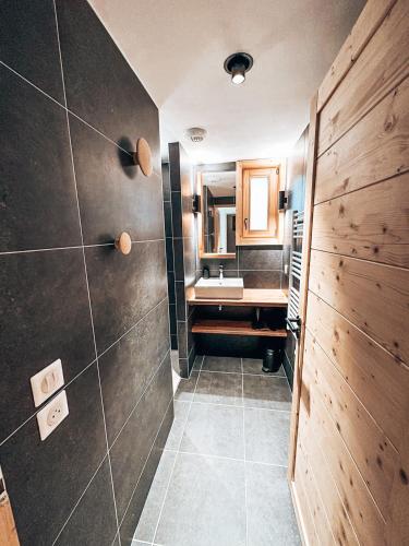 une salle de bain avec un lavabo, une douche et un miroir dans l'établissement Génépi, Appartement de charme 6 pers., au Monêtier-les-Bains