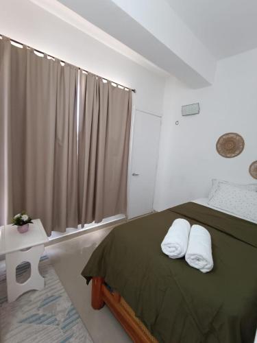 a bedroom with a bed with two pillows on it at Margarita & More, Ocean in Porlamar