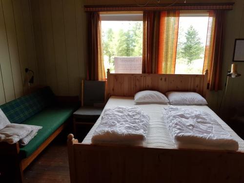 a bedroom with a large bed and a window at Løkhaugen - Historisk landsted in Slettvik