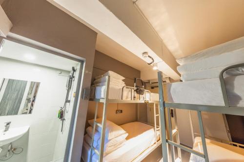 a small room with bunk beds and a sink at D'Nova Hotel Kallang in Singapore