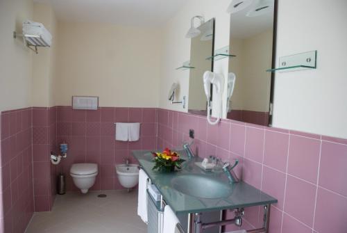 a pink bathroom with a sink and a toilet at La Isla Resort in Pontecagnano