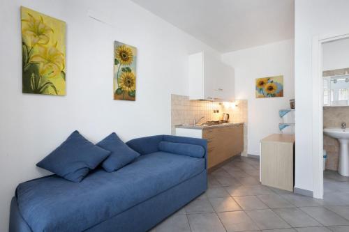 a living room with a blue couch and a kitchen at gli ulivi di montalbano 1 in La Spezia