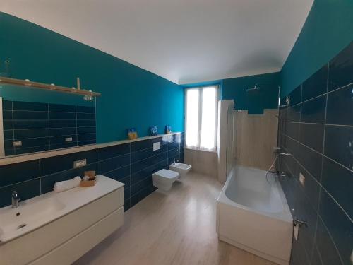 bagno blu con vasca, lavandino e servizi igienici di Le Stanze del Corso ad Ascoli Piceno