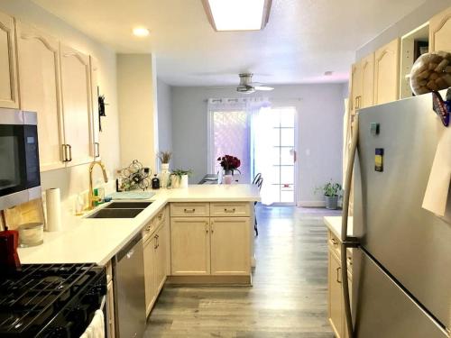 a kitchen with a refrigerator and a stove top oven at Gorgeous Serene Gated Newly Remodeled Townhouse in Las Vegas