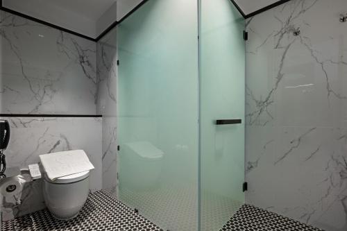 a bathroom with a glass shower with a toilet at The George Penang by The Crest Collection in George Town