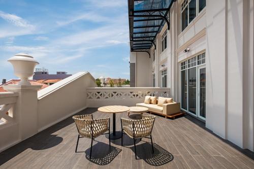 a balcony with a table and chairs and a couch at The George Penang by The Crest Collection in George Town