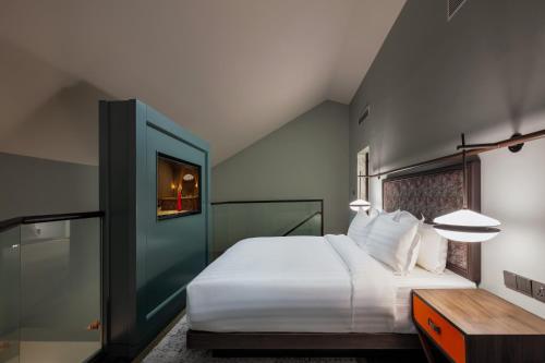 a bedroom with a large white bed and a table at The George Penang by The Crest Collection in George Town
