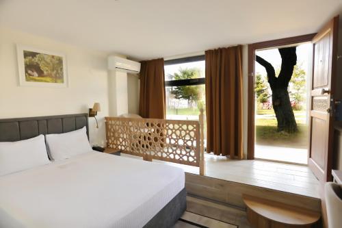 um quarto com uma cama e uma grande janela em Dedeman Van Resort & Aquapark em Van