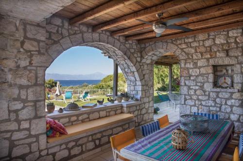 a stone house with a table and a window at Villa Leon in Chalkida