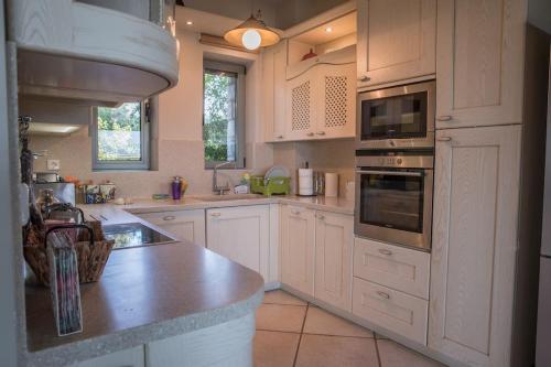 a kitchen with white cabinets and a counter top at Villa Leon in Chalkida