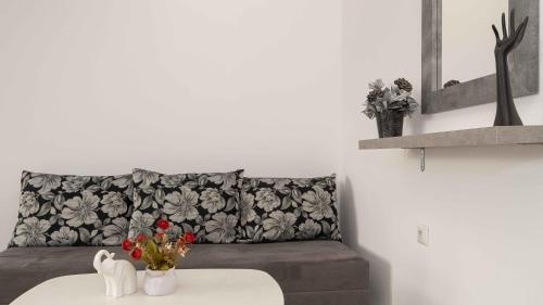 een woonkamer met een bank en een tafel met bloemen bij Sozopol Lifestyle A27 in Sozopol