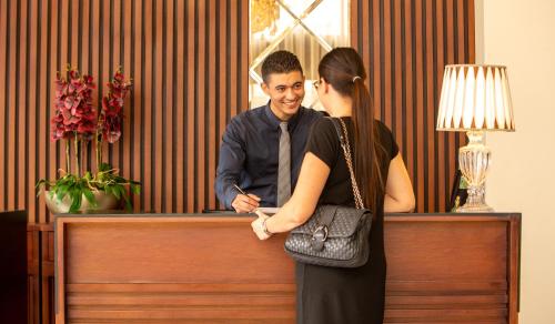 a man and a woman standing at a desk at Fourteen Hotel Ain Sebaa in Casablanca