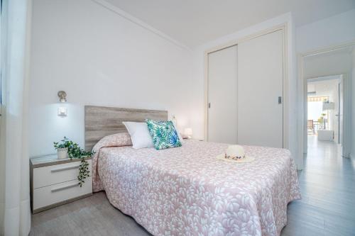 Dormitorio blanco con cama con colcha rosa en Apartment Meda Chica, en Roses