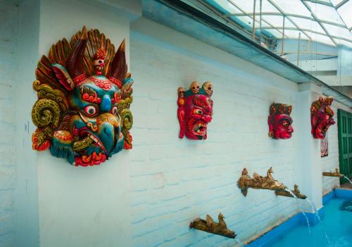 a wall with colorful masks on a wall at Maya Manor Boutique Hotel by KGH Group in Kathmandu