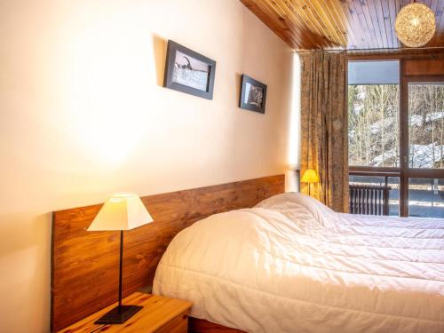 une chambre avec un lit et une grande fenêtre dans l'établissement Appartement rénové 2 pièces à Val-d'Isère, balcon, animaux acceptés - FR-1-694-241, à Val dʼIsère