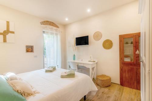 ein weißes Schlafzimmer mit einem Bett und einem Schreibtisch in der Unterkunft Il Piccolo Borgo - con vista in Certaldo