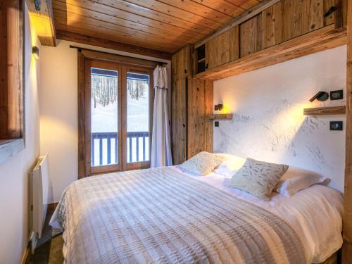 une chambre avec un lit et une grande fenêtre dans l'établissement Appartement duplex de haut standing, skis aux pieds, 82m², 8 pers., cheminé, au cœur de Val d'Isère - FR-1-694-305, à Val dʼIsère