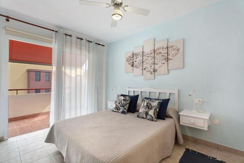 ein Schlafzimmer mit einem Bett mit zwei Gemälden an der Wand in der Unterkunft Sol y Mar in Puerto de Santiago