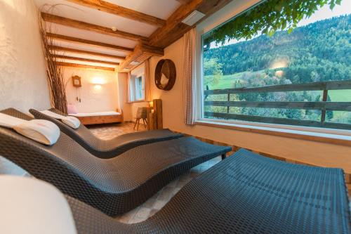 a room with two beds and a large window at Sonnleiten Sonnenadler 1 in Collepietra