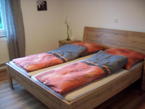 two beds with orange and blue pillows on them at Ferienoase im Zottbachtal in Pleystein