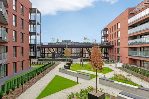 einen Innenhof in einem Gebäude mit Bäumen und Gebäuden in der Unterkunft Downtown Apartments Riverside Nadmotławie Estate - Gym & Sauna in Danzig