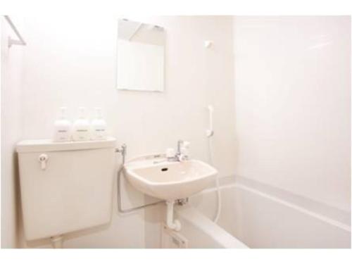 uma casa de banho branca com um lavatório e uma banheira em Hotel Hanabi - Vacation STAY 67110v em Tóquio