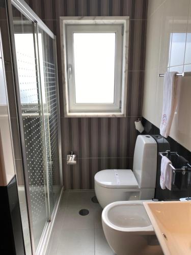a bathroom with a shower and a toilet and a sink at Motel Paraíso do Braseiro in Vila Nova de Gaia