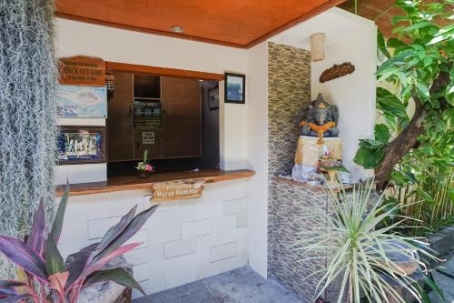a kitchen with a counter and a statue in a garden at Wayan Homestay Sanur in Sanur