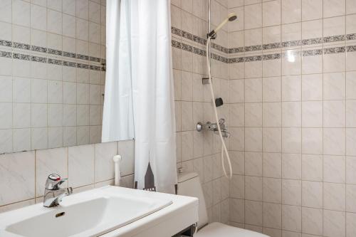 a bathroom with a sink and a toilet and a shower at Villa Uuttu in Kuusamo