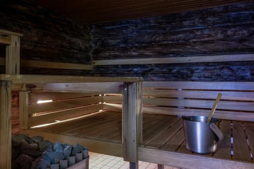 a sauna in a wooden cabin with a bucket at Villa Uuttu in Kuusamo