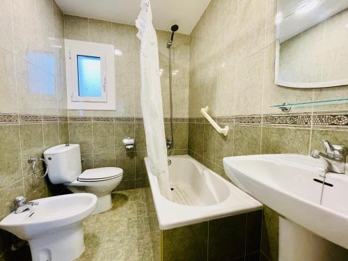 een badkamer met een toilet, een wastafel en een bad bij Costa Daurada Apartaments - CYE 6 II in Salou