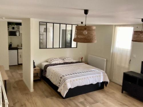 a bedroom with a bed and a window at Studio dans un parc verdoyant in Andrézieux-Bouthéon