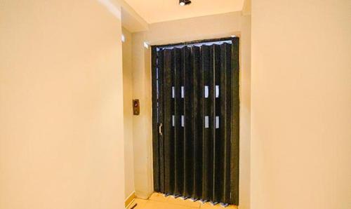 a window with black curtains in a room at FabHotel Earth - Nr Guindy Industrial Estate in Chennai