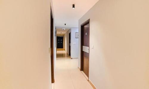 a hallway with white walls and a hallway with a door at FabHotel Earth - Nr Guindy Industrial Estate in Chennai