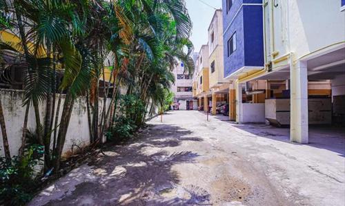 an empty street with palm trees and buildings at FabHotel Earth - Nr Guindy Industrial Estate in Chennai
